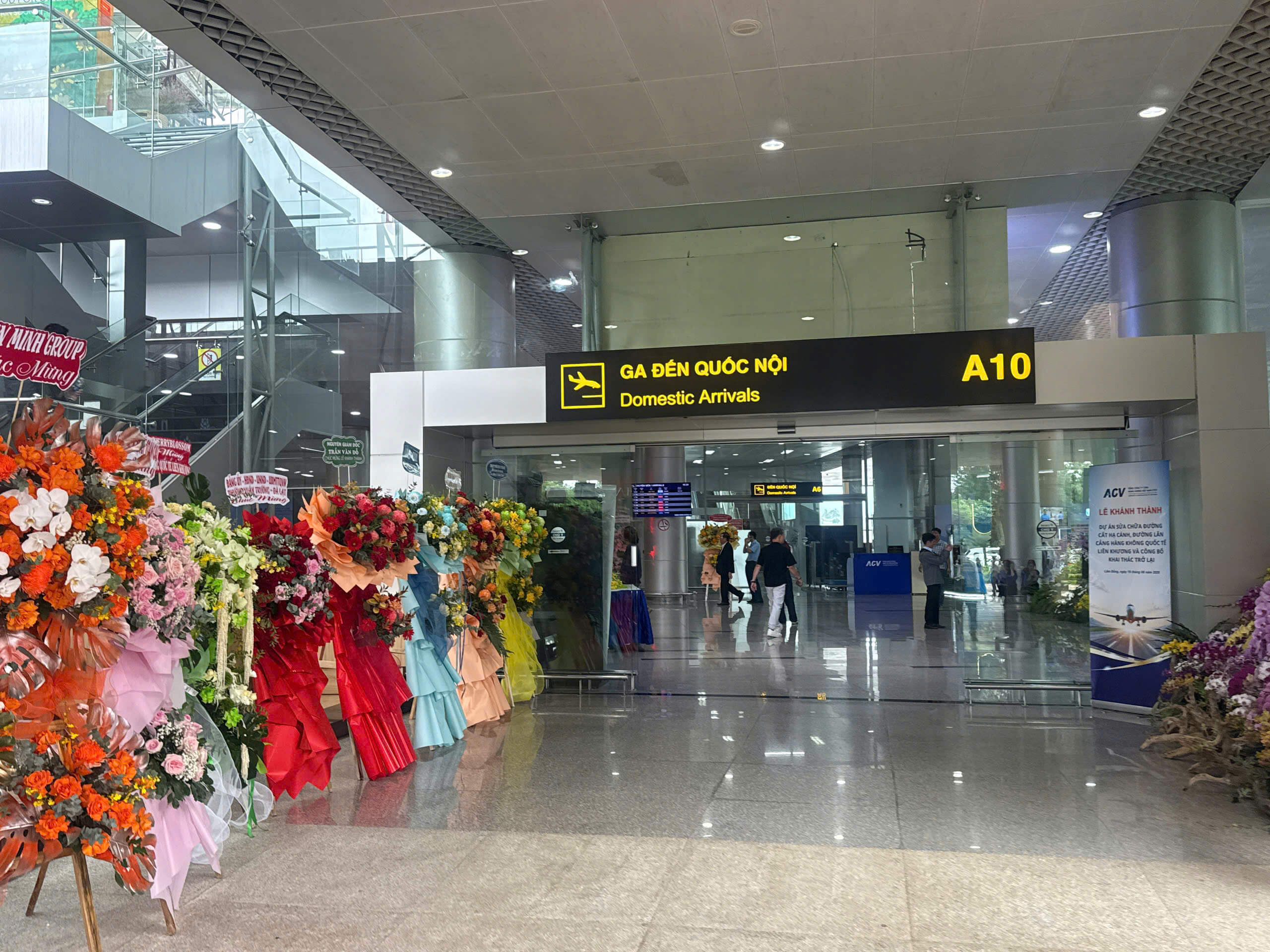 Hoa chúc mừng xếp dọc lối vào cửa A10 ga đến quốc nội Hàng hoa chúc mừng nhiều màu sắc xếp dọc lối vào Đến quốc nội A10 sân bay Liên Khương