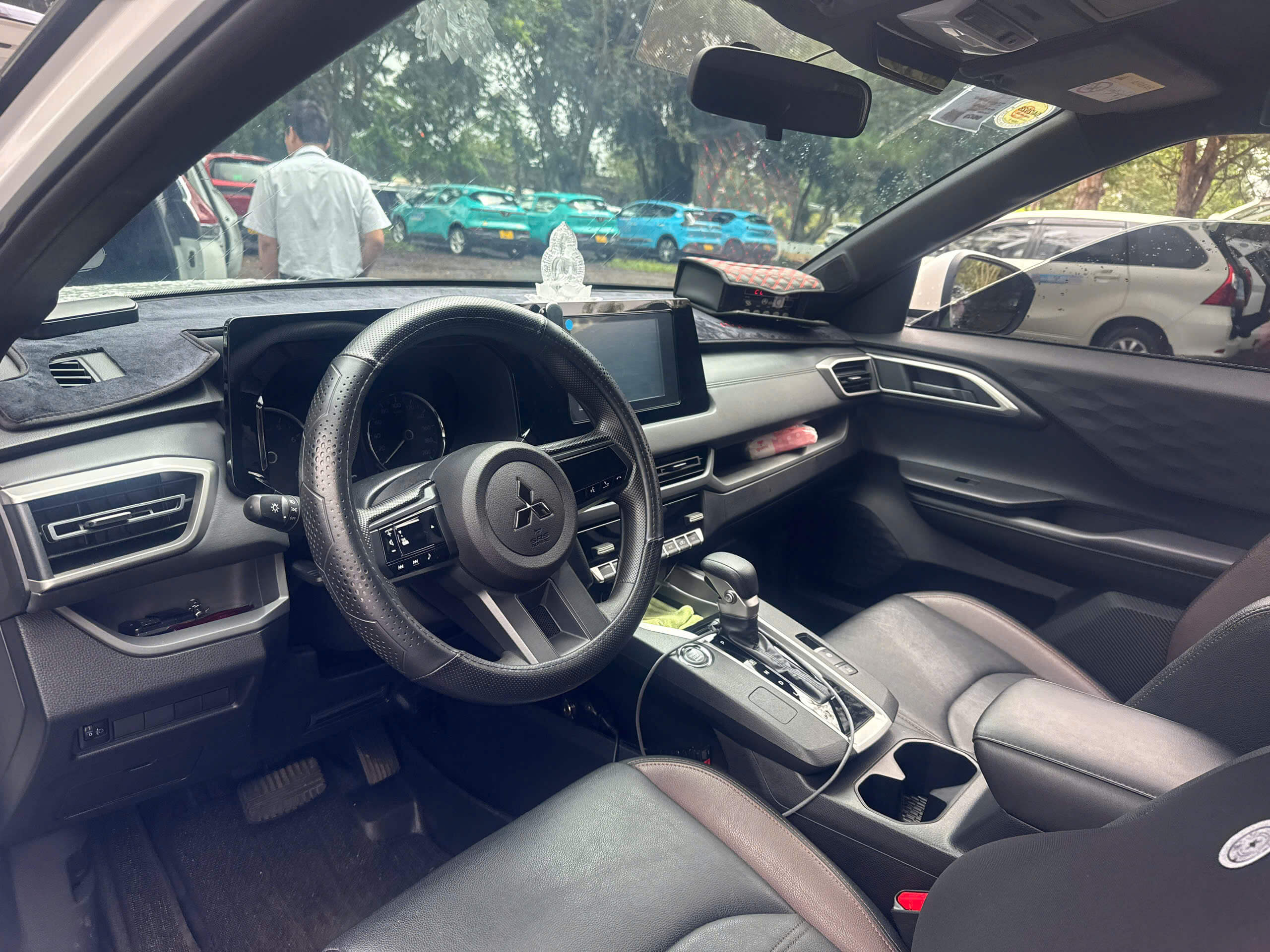 Nội thất xe taxi Đức Trọng đậu tại bãi đỗ gần sân bay Liên Khương Vô lăng và bảng điều khiển xe taxi Đức Trọng, phía sau là đội xe đậu tại bãi đỗ